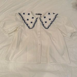 White blouse with blue embroidery
